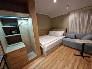 Habitación pequeña con cama y sofá en Hotel Wehra, en Wehr