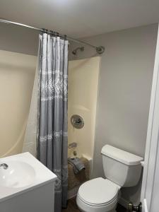 a bathroom with a white toilet and a sink at Lincoln House Motel in Lincoln