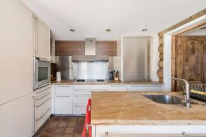 cocina con armarios blancos y encimera de madera en Spectacular Chalet with 5 ensuite bedrooms and sauna, en Chamonix-Mont-Blanc