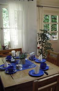 una mesa de madera con platos azules y servilletas. en Pension Reuss - Hotel garni, en Erfurt