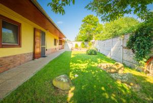 a house with a grass yard next to a building at Zöld dió Vendégház in Mezőkövesd