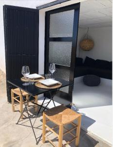 un tavolo nero con bicchieri da vino e due sedie di Casa Luz a El Pozo de los Frailes