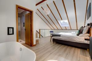 a bedroom with a bed and a tub in a room at The Owl Barn Wiltshire - Sarsen in Swindon