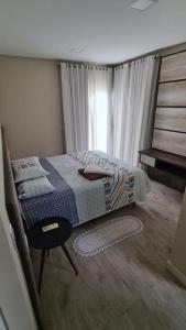 1 dormitorio con 1 cama, 1 silla y 1 ventana en Casa Grande Pomerode, en Pomerode