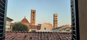 Blick auf eine Stadt mit zwei Türmen und Dächern in der Unterkunft Girasole 1 in Lucca