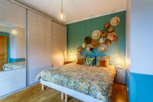 1 dormitorio con 1 cama con sombreros en la pared en Les Magnolias, en Oullins