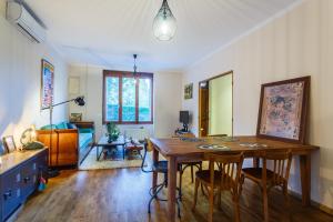 een woonkamer met een houten tafel en stoelen bij Les Magnolias in Oullins