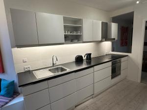 a kitchen with white cabinets and a sink at Central, Historical, Unique & Modern Apartment CPH in Copenhagen
