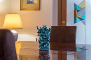 uma estatueta de vidro azul de uma coroa sobre uma mesa em A Casa del Gioielliere em Palermo