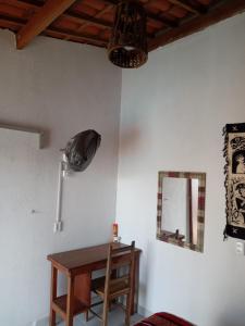 Habitación con mesa y espejo en la pared. en Minha casa, en Mossoró
