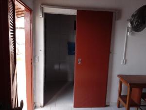 una puerta abierta a un baño con puerta roja en Minha casa, en Mossoró