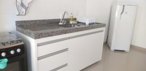 a kitchen with a sink and a refrigerator at Apartamento no centro próximo a Jk in Palmas