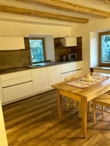 a kitchen with a table with a dog sitting on it at Cèsa Sès da mont in Livinallongo del Col di Lana