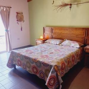 a bedroom with a large bed with a wooden headboard at Casa Munay in Maimará