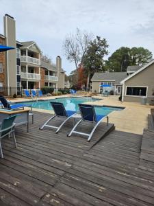 a swimming pool with two chairs and a table at Heart of Huntsville in Huntsville
