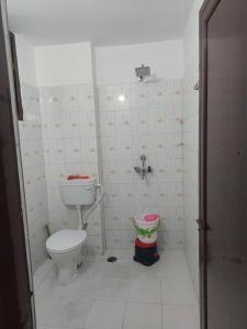 een badkamer met een toilet en een emmer erin bij Royal Home Stay in Patna