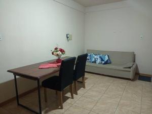 einen Tisch und Stühle mit einem Sofa im Wohnzimmer in der Unterkunft Apto Confortável e espaçoso 01 in Cachoeira do Sul