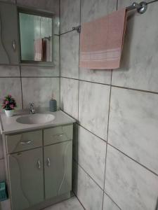 ein Bad mit einem Waschbecken und einem Spiegel in der Unterkunft Apto Confortável e espaçoso 01 in Cachoeira do Sul