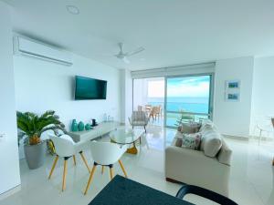 a living room with a couch and a table and chairs at Magico Apartamento Frente al Mar 4 Habitaciones O62 in Coveñas