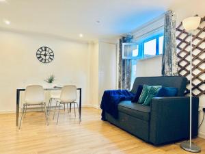 uma sala de estar com um sofá, uma mesa e cadeiras em Sutton - Ground Floor Flat By The High Street em Sutton