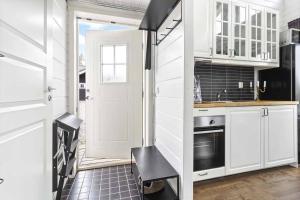 a kitchen with white cabinets and a white door at Loft ”Aurora” Ski Resort in Kåbdalis