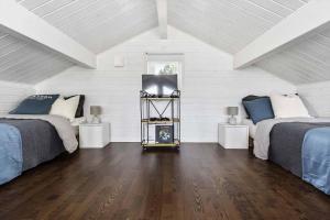 a bedroom with two beds and a television in it at Loft ”Aurora” Ski Resort in Kåbdalis