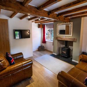 uma sala de estar com um sofá e uma lareira em Southwell Holiday Cottage - Lavender Cottage em Southwell