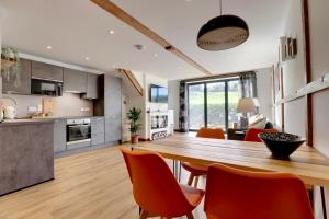 a kitchen and living room with a wooden table and chairs at The Owl Barn Wiltshire - Chalk in Swindon
