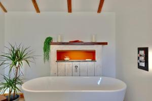 a white bath tub in a room with plants at The Owl Barn Wiltshire - Chalk in Swindon