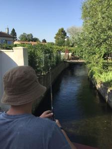 a man holding a fishing pole in a river at studio avec jardin en campagne in Le Thor