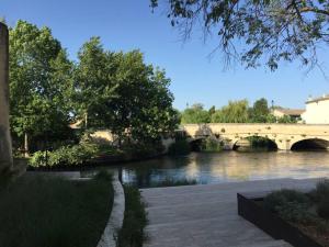 a bridge over a river next to a river at studio avec jardin en campagne in Le Thor