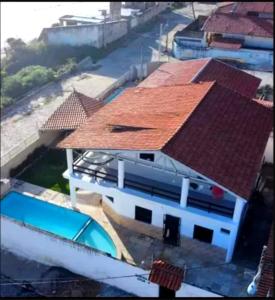 a house with a red roof and a swimming pool at Pousada e Hostel Lua de Tomate in Caucaia