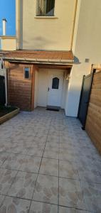 a building with a garage with a door and a patio at Studio Grand Confort à Houilles in Houilles