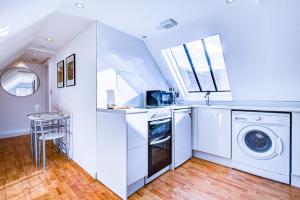 a white laundry room with a washer and dryer at Spacious One Bedroom Apartment in The Heart Of Brentwood in Brentwood