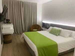 una camera da letto con un letto grande con una coperta verde di Diamantchery - Vue mer avec Deck privatif a Le Diamant