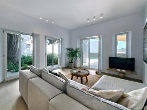 un soggiorno con divano e TV di Private Luxury Scarlet beachfront villa, Molos, Paros a Molos Parou