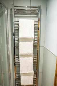wieszak na ręczniki w łazience z białymi ręcznikami w obiekcie 2 Bedroom Charming & Luxury Malt Cottage, Garden, Netflix, Free Parking w mieście Bourton-on the-Water