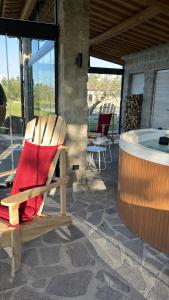 een schommelstoel op een patio met een hot tub bij Villa Paladini in Montefiascone