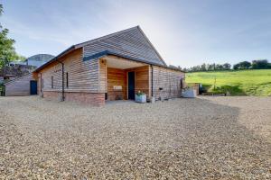 um celeiro com uma entrada de cascalho em frente a ele em The Owl Barn Wiltshire - Flint em Swindon