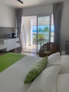 una camera da letto con un letto e vista sull'oceano di Diamantchery - Vue mer avec Deck privatif a Le Diamant