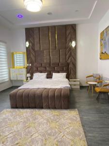 a bedroom with a large bed with a large headboard at Luxury 4 bedroom shared shortlet apartment lekki in Lagos