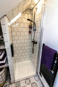 uma casa de banho com uma cabina de duche e uma toalha roxa em Loft apartment in Accrington Stunning Lancashire views em Church