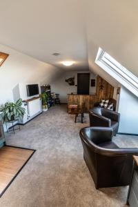 a living room with leather chairs and a tv at Loft apartment in Accrington Stunning Lancashire views in Church