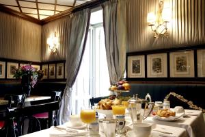 ein Esszimmer mit einem Tisch voller Speisen und Orangensaft in der Unterkunft Il Relais in Verona