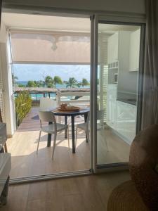 una sala da pranzo con tavolo e vista sull'oceano di Diamantchery - Vue mer avec Deck privatif a Le Diamant