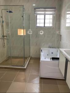 a bathroom with a shower and a bath tub at Luxury 4 bedroom shared shortlet apartment lekki in Lagos