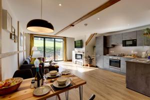 a kitchen and a living room with a table at The Owl Barn Wiltshire - Flint in Swindon