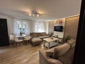 a living room with a couch and a table at Apartamenty Ostryga Łeba in Łeba