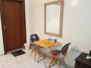 mesa y sillas en una habitación con espejo en Bzxmax Guest House, en Al Ain