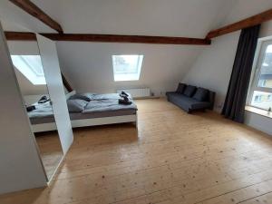 uma sala de estar com uma cama e um espelho em Kinderklinik Dachwohnung Lion's Head 1B em Siegen